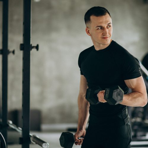 Young sports man training at the gym